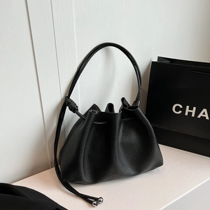 Minimalist black pebble leather bucket bag with drawstring closure and silver ball detail