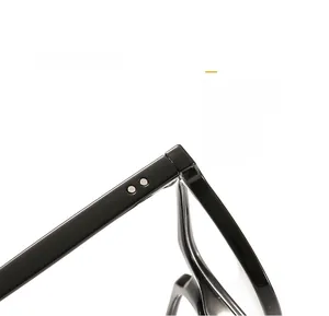 Detail of black glossy eyeglass frame hinge with silver rivets on a white background