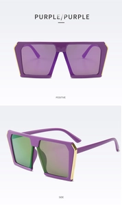 Macro detail of oversized purple sunglasses with golden metal trim and reflective lenses