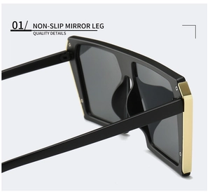 Detail of oversized sunglasses showing non-slip mirror legs and gold temple accents
