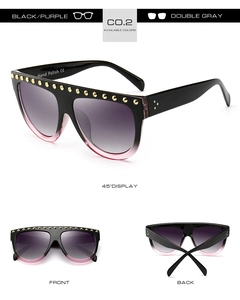 Détail de lunettes de soleil larges avec dégradé noir-violet et rivets dorés en métal