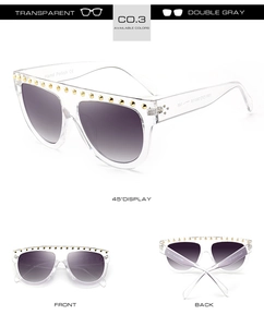 Détails de lunettes de soleil transparentes avec clous dorés et verres dégradés gris