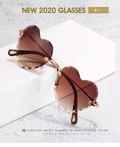 Detail of rimless heart sunglasses with brown gradient lenses and gold metal frames