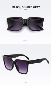 Detail of square black sunglasses with purple gradient lenses and gold rivet accents