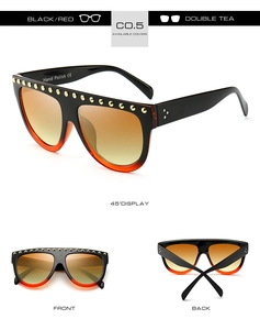 Détails de lunettes de soleil dégradées noir et rouge avec clous dorés et verres thé