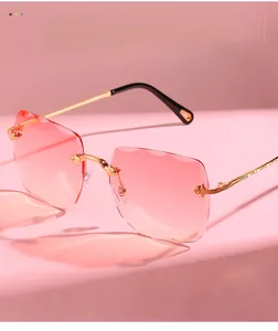 Detail of rimless square sunglasses with pink gradient lenses and gold carved metal temples