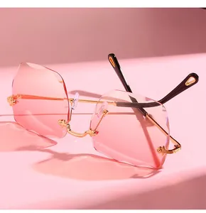 Detail of pink rimless square lenses with wavy cut edges and golden metal temples