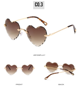 Detail view of heart-shaped rimless sunglasses with wavy edges and golden frame
