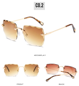 Detail view of rimless square sunglasses with scalloped gradient lenses and gold temples