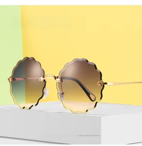Detailed view of wave-edge gradient lenses and engraved golden metal temples on sunglasses
