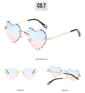 Detail view of heart-shaped rimless sunglasses with blue-pink gradient cut lenses