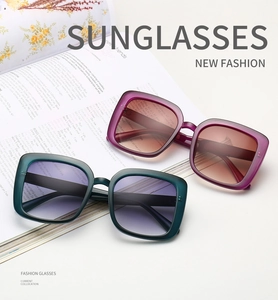 Classic square oversized sunglasses with purple and green frames on magazine background