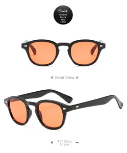 Detail view of glossy black sunglasses with red lenses and silver arrow rivets