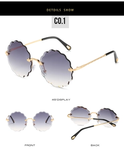 Detail view of purple gradient scalloped lenses and floral engraved gold temples on sunglasses