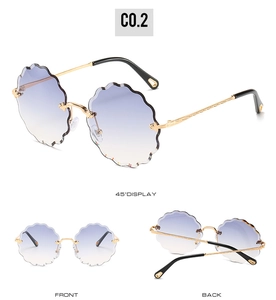 Detail view of rimless floral-cut sunglasses with gradient lenses and gold metal temples