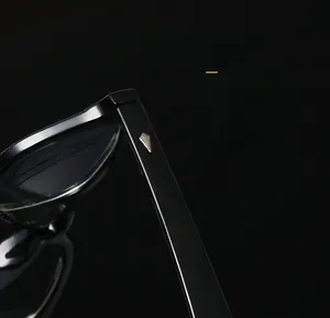 Detail of the glossy black temple hinges with geometric metal rivets on the glasses