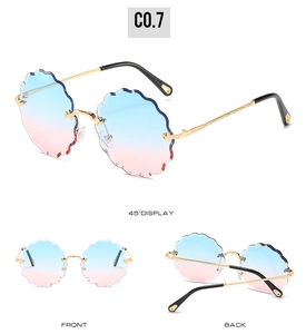 Detail view of cloud-shaped rimless sunglasses with blue-pink gradient lenses and gold frame