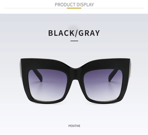 Close-up of black cat-eye sunglasses featuring gradient lenses and gold hinge accents