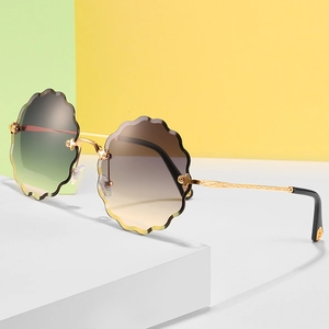 Rimless petal-shaped sunglasses for women with brown-green gradient lenses and gold temples