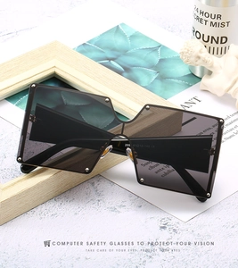 Close-up of oversized square sunglasses with silver stud accents and inner temple details