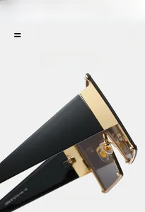 Macro view of gold metal hinges and black polished temples on oversized square sunglasses