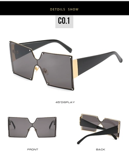Detail view of square oversized sunglasses with gold metal accent on black frames