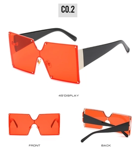 Detail view of square oversized sunglasses with orange lenses and silver stud accents