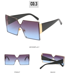 Detail view of oversized square sunglasses featuring gradient lenses and metal hinges
