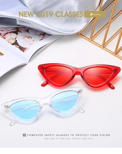 Gros plan de lunettes de soleil œil-de-chat vintage rouges et bleu clair sur soie élégante