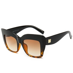 Oversized cat-eye sunglasses in tortoiseshell and black with gold metal accents