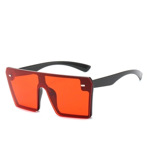 Oversized black square sunglasses with red lenses and silver rivets at 45-degree angle