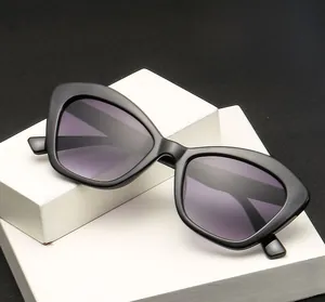 Fashionable black cat-eye sunglasses with purple gradient lenses on a display stand