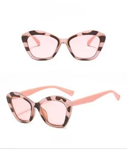 Close-up of retro cat-eye sunglasses featuring leopard print frames and pink jelly lenses