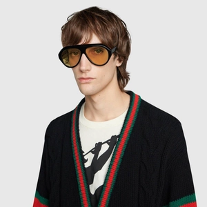 Close-up of retro oversized black sunglasses with amber lenses on a fashion model