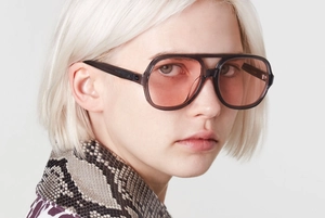 Gros plan de lunettes de soleil carrées à double pont avec monture grise et verres oranges
