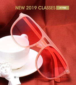 Détail de lunettes de soleil carrées rose translucide à double pont sur velours