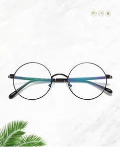 Détail de lunettes vintage rondes en métal avec filtre anti-lumière bleue sur marbre