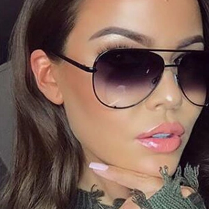Detail view of female model wearing aviator sunglasses with purple gradient lenses