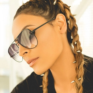 Detail of aviator sunglasses with black metal frame and spiked hair accessories on model