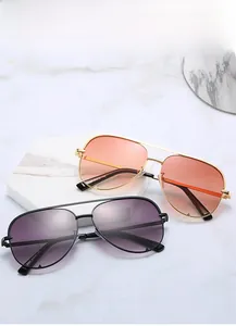 Close-up of metal aviator sunglasses with gradient lenses on marble display stands