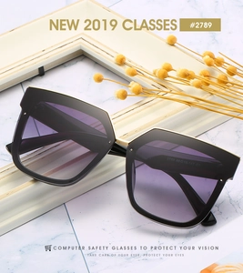 Détail des lunettes de soleil carrées oversize avec verres dégradés violets et pont doré