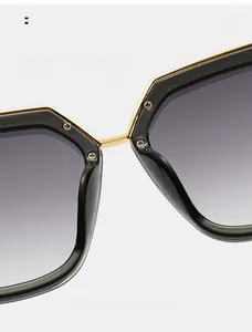 Détail de lunettes de soleil carrées montrant les plaquettes et le pont en or