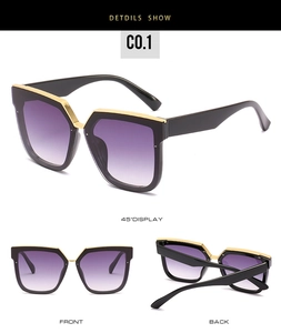 Détail des lunettes de soleil carrées avec barre dorée et verres dégradés violets