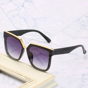 Lunettes de soleil carrées avec verres dégradés violets et détails dorés sur la monture