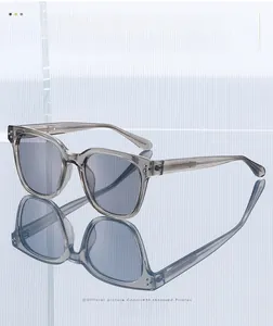 Detailed view of square transparent grey sunglasses with metallic rivets and dark lenses