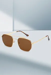 Close-up of golden double bridge aviator sunglasses with gradient brown lenses