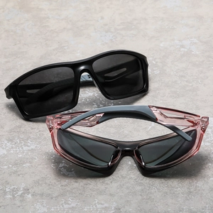 Polarized cycling sunglasses in black and translucent pink frames on stone surface