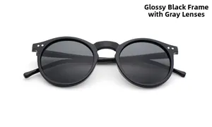 Detail of round vintage sunglasses with glossy black frame and silver metal stud accents