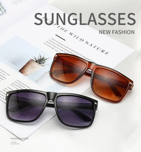 Detailed shot of square frame sunglasses with metal rivets and gradient lenses