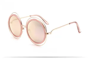 Vue latérale de lunettes de soleil rondes à double monture dorée et verres roses